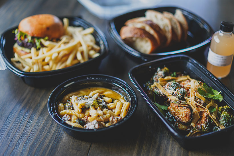 Bistro food laid out in take out containers